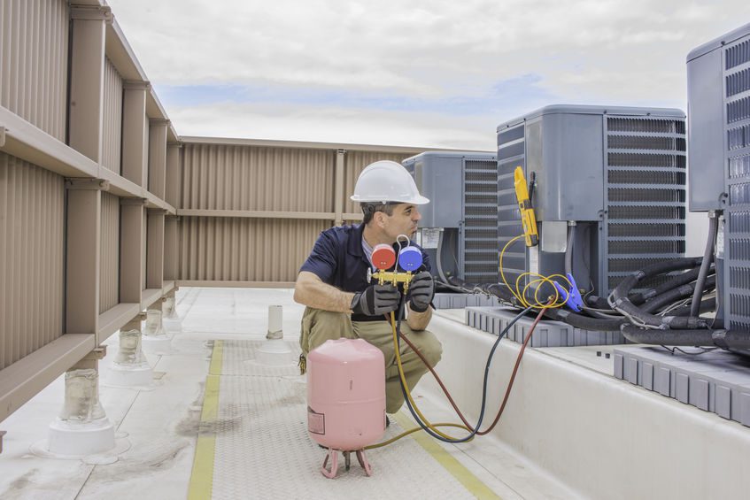 HVAC service technician charging a condensing unit with 410A refrigerant