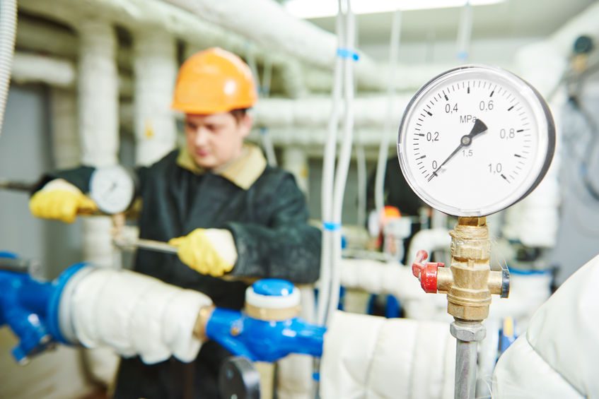 Closeup of manometer, pipes and faucet valves of heating system in a boiler room