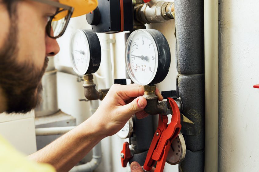 plumber installing pressure meter for house heating system