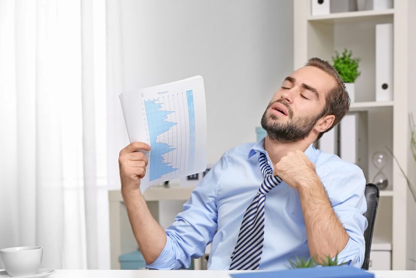 Young man feeling hot in office